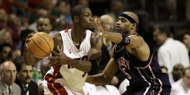 Miami Heat's Dwyane Wade, left, who scored 23 points, is guarded by New Jersey Nets' Vince Carter, who scored 32 points, Monday, Nov. 7, 2005, in Miami. The Heat won 90-89.