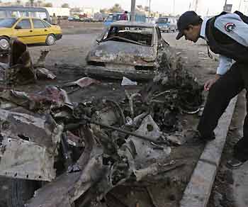 An Iraqi policeman inspects the remains of a car bomb that exploded on Wednesday night in a north Baghdad district November 10, 2005.