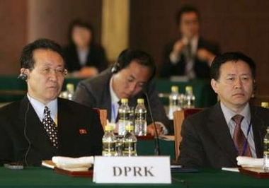 North Korean chief negotiator Kim Kye-gwan (L) and a member of his delegation listen to opening remarks at the latest round of six-party talks at Diaoyutai State Guest House in Beijing, November 9, 2005.