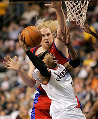 Allen Iverson (front) shoots under pressure from the Los Angeles center Chris Kaman during the third quarter of their NBA game in Philadelphia November 13, 2005.