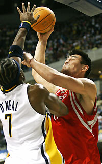 Houston Rockets center Yao Ming of China (R) goes up strong shooting over Indiana Pacers forward Jermaine O'Neal in the first quarter of their NBA game in Indianapolis November 20, 2005.