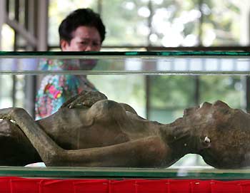 A visitor views the preserved body of an AIDS victim at a hospital inside the Buddhist Prabat Namphu Temple in central Lopburi province, 150 km (93 miles) northeast of Bangkok, November 28, 2005.