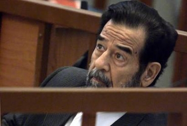 Former Iraqi president Saddam Hussein listens to Presiding Judge Rizgar Mohammed Amin as his trial resumes in Baghdad November 28, 2005.