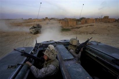 U.S. Marine Lance Cpl. Kevin Van Arsdale, left, of Brick, New Jersey and Cpl. Richard Guadalupe of Union City, New Jersey, provide security at the back of their Amphibious Assault Vehicle in Saadah, Iraq, eight miles from Syria, Thursday, Dec. 1, 2005.