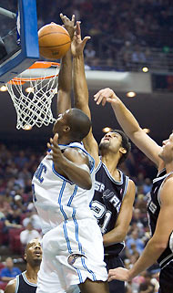 jSan Antonio Spurs forward Tim Duncan (C) knocks away the ball as Orlando Magic forward Dwight Howard (L) tries to score during first half NBA action in Orlando, Florida, December 5, 2005. To the right of Duncan, Spurs center Rasho Nesterovic, of Slovenia, also goes for the block.