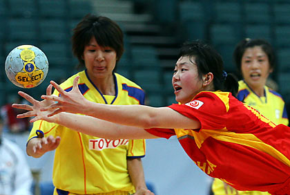 en Juan Wu of China (C) tries to catch the ball as Japan's Mineko Tanaka (R) and Akiko Kinjo watch during their preliminary round match at Women's World Handball Championships in St. Petersburg December 5, 2005.