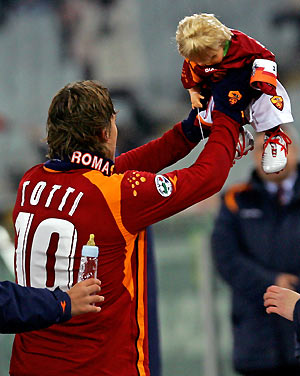 Francesco Totti celebrates and holds a doll after scoring against Chievo during their Italian Serie A soccer match at the Olympic Stadium in Rome December 21, 2005. [Reuters]
