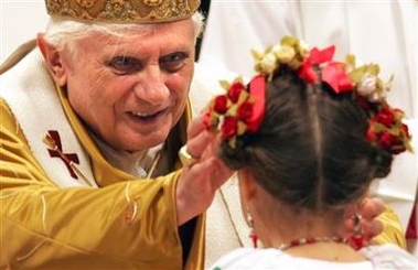 Pope Benedict XVI touches a girl's forehead during midnight mass, which he led, in Saint Peter's Basilica at the Vatican, December 25, 2005.