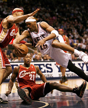 ew Jersey Nets guard Vince Carter (15) controls ball after a collision with Cleveland Cavaliers guard Eric Snow (20) in the first quarter of their NBA basketball game in East Rutherford, New Jersey December 27, 2005.