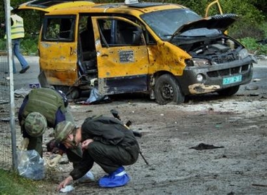 Israeli security collect evidence at the scene of a suicide bombing attack at an Israeli army checkpoint near the West Bank town of Tulkarem Thursday Dec. 29, 2005.