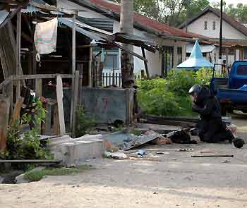 A member of bomb squad inspects the site of bomb blast at the market in the town of Palu, capital of volatile Central Sulawesi province in Indonesia on December 31, 2005.
