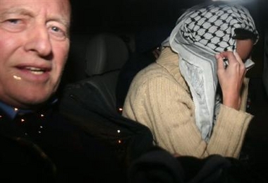 British aid worker Kate Burton, 25, right, covers her face with an Arab head scarf as she sites next to her father Hugh after crossing from the Gaza Strip into Israel at the Israeli side of the Erez crossing l early Saturday Dec. 31, 2005.
