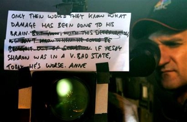 A television crew reports on Israeli Prime Minister Ariel Sharon's health condition using cue cards, outside the Hadassah Hospital in Jerusalem Friday Jan. 6, 2006.