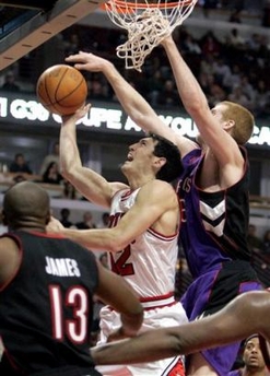 Chicago Bulls Kirk Hinrich, center, is fouled on his way to the basket by Toronto Raptors' Matt Bonner, right, as the Raptors' Mike James (13) looks on during the fourth quarter of an NBA basketball game Monday, Jan. 9, 2006 in Chicago.