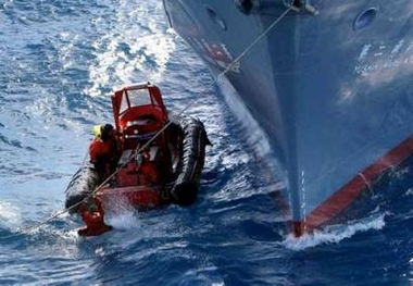 A Greenpeace activist grabs the rope from a harpoon as he tries to get back aboard an inflatable boat after a harpoon fired from a Japanese whaling ship narrowly missed them in the Southern Ocean January 14, 2006.