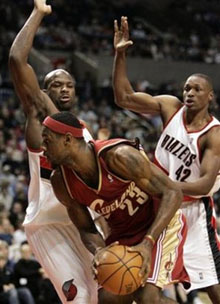LeBron James (23) looks for room to manuever against Portland Trail Blazers' Ruben Patterson, left, and Theo Ratliff during NBA basketball first quarter action in Portland, Ore., Sunday, Jan. 15, 2006.
