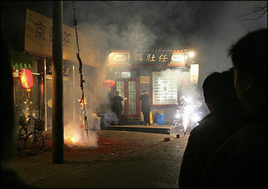 Fireworks are lit during loud celebrations moments after midnight in an old Beijing neighborhood near the ancient Bell Tower.