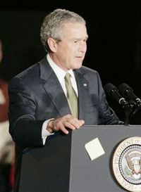 A 3M Post-it note that President Bush placed on the front of the podium moments before falls as he prepares to speak at the Maplewood, Minn., company, known for its yellow Post-its, Thursday, Feb. 2, 2006 . Bush called for promoting research and technnology in a competitive world. (AP