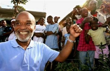 Haitian presidential candidate Rene Preval waves to supporters after casting his ballot in the hamlet of Marmelade, near Gonaives, February 7, 2006.
