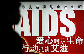 A person waits for a train in front of an AIDS awareness poster in a Beijing subway station last month.