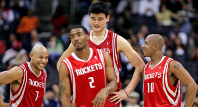 The Houston Rockets' Yao Ming (2nd R) of China laughs with teammates (L-R) David Wesley, Luther Head, and Keith Bogans during the fourth quarter of their NBA game against the Los Angeles Clippers in Los Angeles, February 14, 2006.