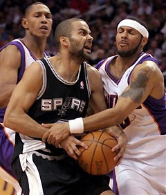 San Antonio Spurs guard Tony Parker, center, of France, is fouled by Phoenix Suns guard Eddie House, right, as Suns guard Raja Bell, left, loooks on in the fourth quarter of NBA basketball action Thursday, March 9, 2006, in Phoenix. 