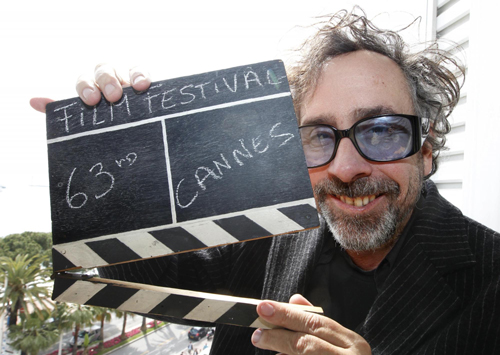 Tim Burton holds a film clapper in Cannes