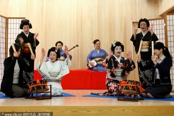 Geishas teach tourists how to perform traditional Taiko drum during an event on July 13, 2011 in Awara city, Fukui prefecture, Japan. Geisha performance in Awara has a history of more than 100 years and presently 12 geisha women are living in the Awara Onsen town. Geisha shows promote tourism in central Japan