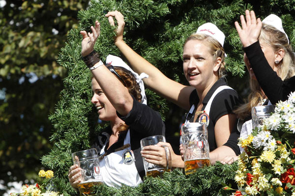 People in traditional Bavarian clothes toast with beer mugs while taking part in the Parade of the Landlords and Breweries during the opening of the 178th Oktoberfest in Munich September 17, 2011. World's biggest beer fest opens in Munich