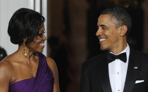 US President Barack Obama smiles with his wife Michelle as they wait to receive South Korean President Lee Myung-bak and his wife Kim Yoon-ok for a state dinner in their honor at the White House in Washington Oct 13, 2011. Obama, Lee hail long-sought trade deal