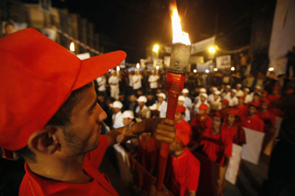 An anti-government protester holds a torch during a ceremony commemorating the 48th anniversary of a revolution that liberated the south of Yemen from British rule, at Taghyeer (Change) Square in Sanaa Oct 13, 2011. Protesters demand ouster of Yemen's president