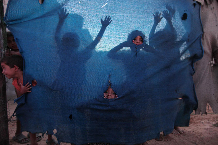 Palestinian refugee children play at a poor suburb in Gaza City before Breaking fast on the Holy month of Ramadan on Aug 7, 2012. Xinhua world images of the year 2012