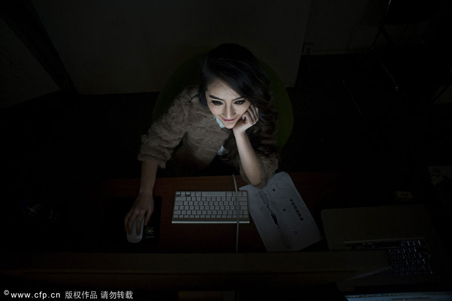 Xia Chenjie reads online fashion news in her spare time in her studio in Hangzhou, on Feb 15, 2012. Taobao models live for clothes
