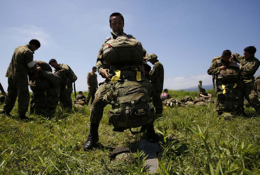 Japanese Ground Self-Defense Force's 1st Airborne Brigade soldiers wear parachutes for a parachute drop training during their military drill at Higashifuji training field in Susono, west of Tokyo, July 8, 2013. Japanese Ground SDF holds military drills in W Tokyo