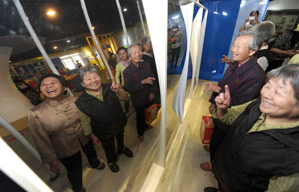 Senior citizens experience magic mirror as they visit a science museum in Hefei, Anhui province, on Oct 13, 2013, during the Chongyang Festival, an occasion to show respect to the elderly. Never too old to learn