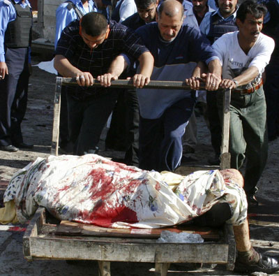 Rescuers remove a body from inside a mosque after suicide bombing in central Baghdad April 7, 2006. Three suicide bombers dressed as women killed at least 79 people at a Shi'ite mosque on Friday in Baghdad, police said, putting more pressure on Iraq's divided leaders to form a government and face up to sectarian violence. [Reuters]