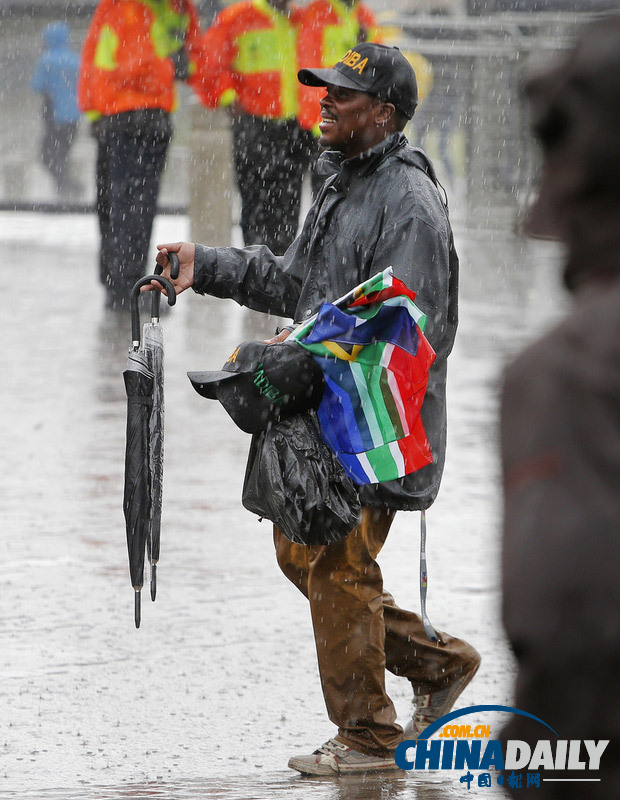 曼德拉追悼會現場：情侶為偉人海報打傘