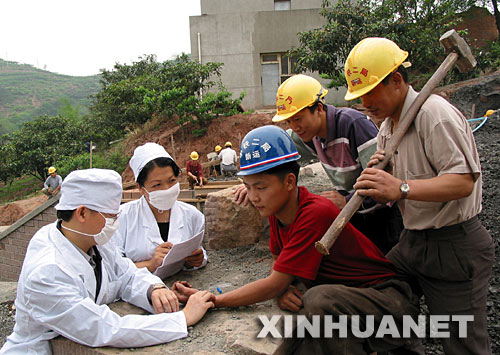  2003年5月9日，中鐵二局巡回防疫小分隊的醫務人員在成都市龍泉驛區白工堰建設工地為施工人員檢查身體。為預防非典傳播，中鐵二局醫務人員深入各建設工地，為施工人員和駐地山村群眾免費檢查身體，宣傳防疫知識。 新華社發 