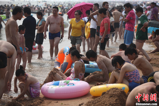 多地遭遇高溫天——青島海濱浴場成“人海”
