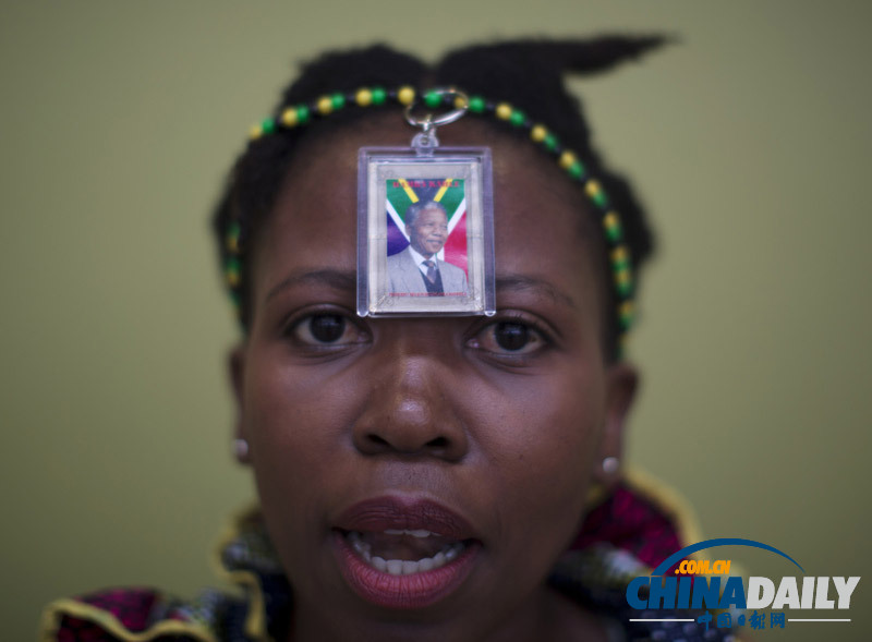 曼德拉追悼會現(xiàn)場:情侶為偉人海報(bào)打傘