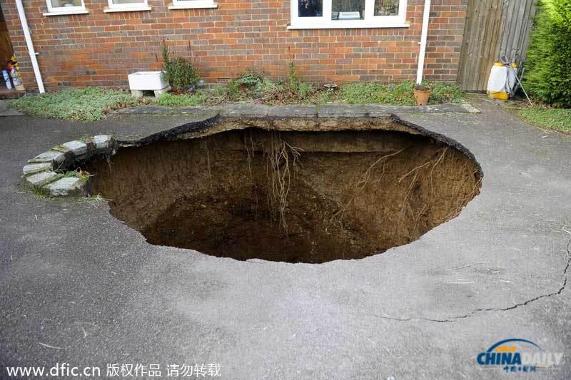 英國居民房屋前驚現(xiàn)大坑 汽車慘遭“吞噬”