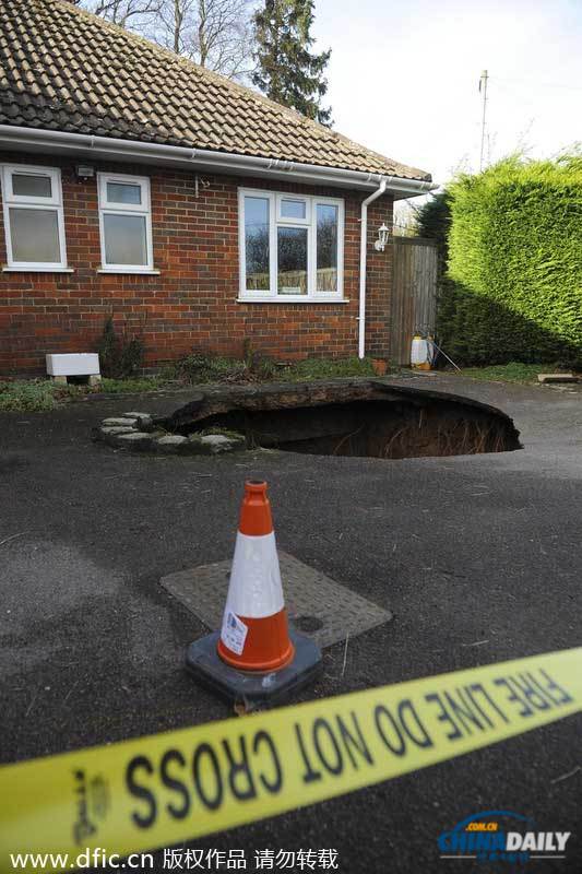 英國居民房屋前驚現大坑 汽車慘遭“吞噬”
