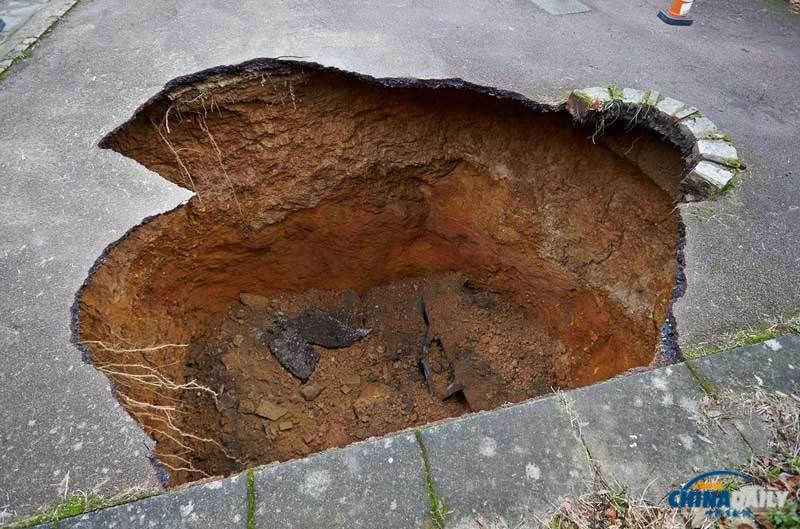 英國居民房屋前驚現大坑 汽車慘遭“吞噬”