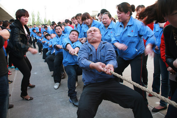 Migrant workers of Jifa Group in Qingdao, Shandong province, have a tug-of-war recently. Liang Xiaopeng / for China Daily More workers staying near home