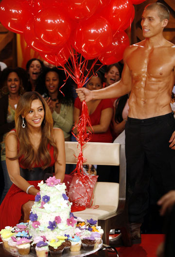 Singer Beyonce (L) is surprised with a birthday cake and balloons while being interviewed for television's