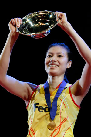 China's Xie Xingfang holds up her trophy after beating France's Pi Hongyan in the women's singles final at the All England badminton championships in Birmingham, England March 11, 2007.