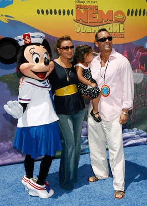 Actress Leah Remini, her daughter Sofia (2nd R) and her husband Angelo Pagan (R) pose with Minnie Mouse as they arrive for a preview of the new