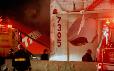 Firemen work around the Airbus A320 belonging to Brazil's TAM airlines as it lies burning next to a building belonging to the same company at Congonhas airport in Sao Paulo July 17, 2007. Airport officials said 174 passengers and crew were on board the Airbus A320 flying from Porto Alegre in southern Brazil when it lost control on landing and skidded off the wet runway.