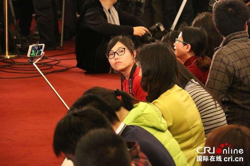兩會新聞發布會 記者用“自拍神器”自拍