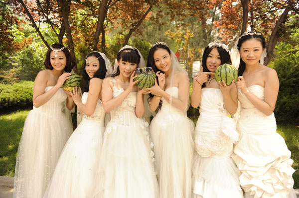 New college graduates, wearing wedding gowns, pose for their graduation photos at Liaocheng University (LCU) in Liaocheng, East China's Shandong province, June 1, 2013. Graduates in wedding gowns honor college years